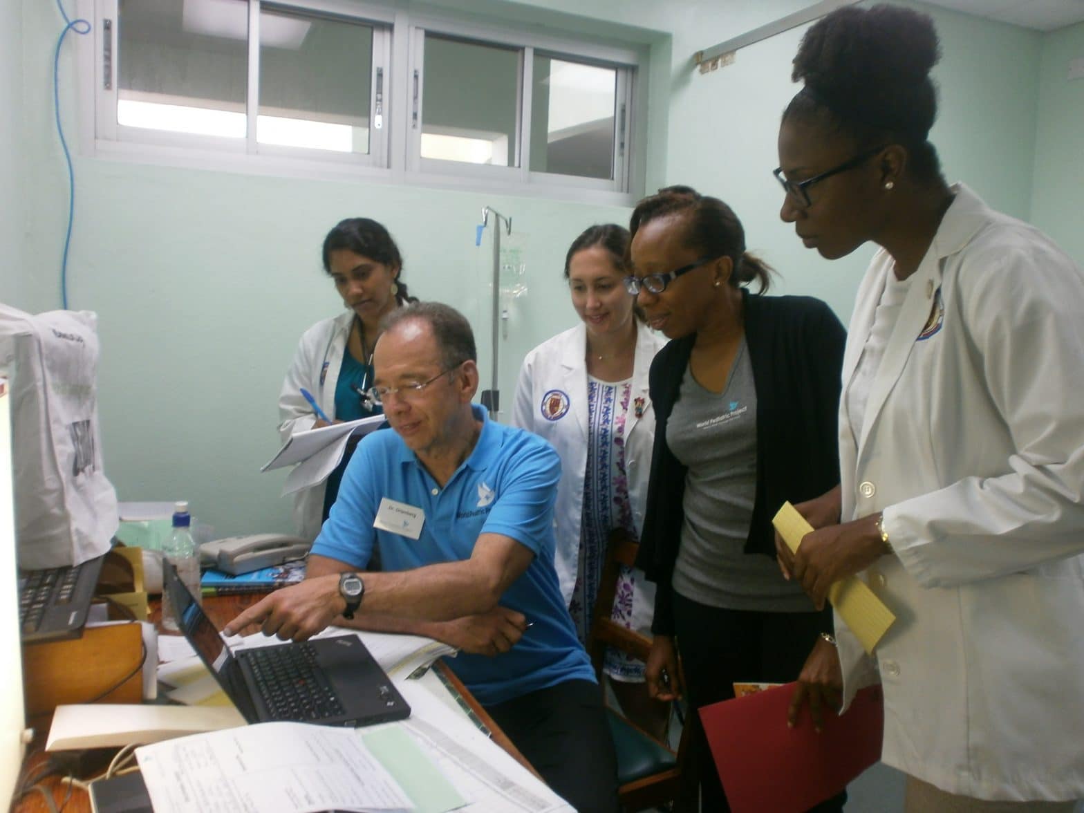 Trinity medical school students looking at a laptop during a clinic