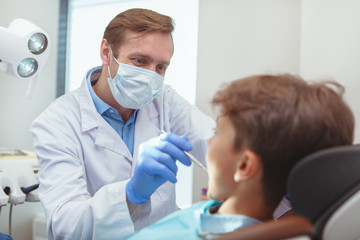 Dentist cleaning the teeth of a child