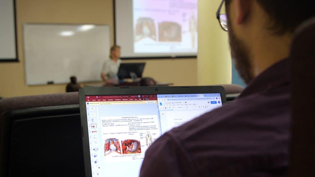 Closeup of a medical school student on his laptop in class