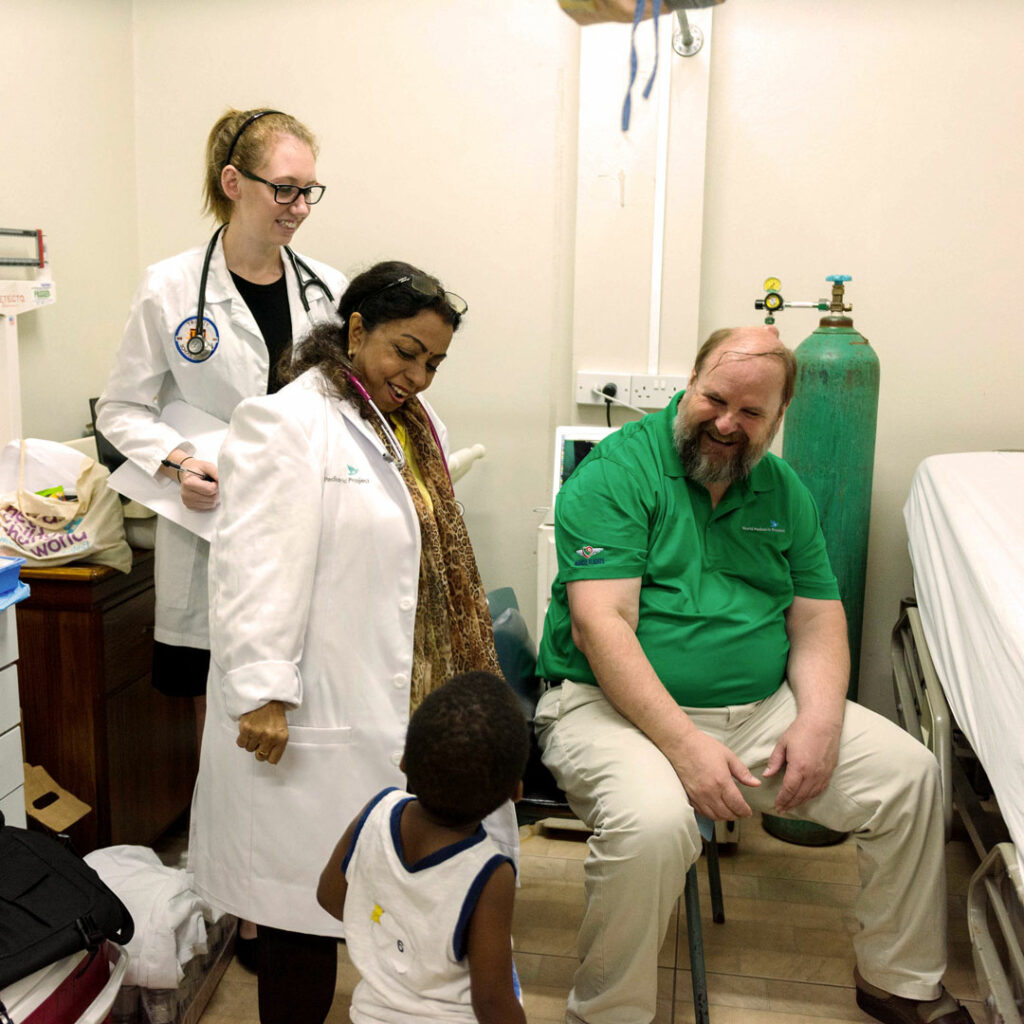 doctors and medical school student participants talking to a young boy