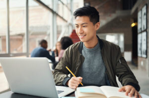 medical school student studying at a desk while participating in pre-med online